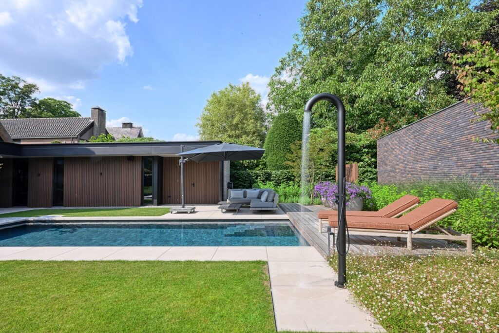 Luxetuin met zwembad, buitendouche, parasol en ligbedden
