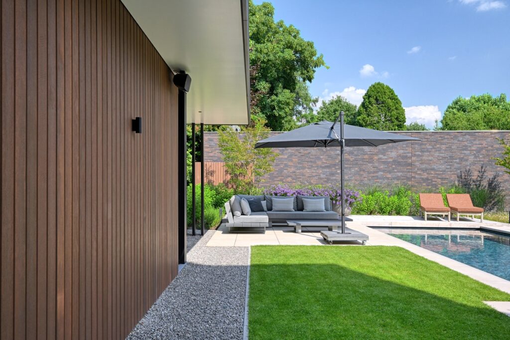 Luxe tuin met zwembad, tuinmeubels en parasol