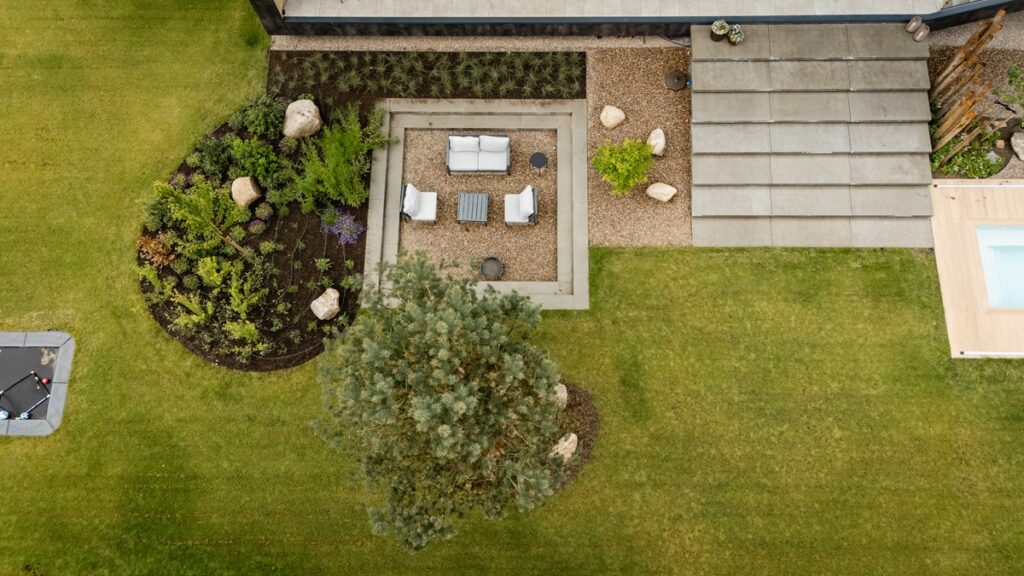Overzichtsfoto luxe tuin met tuinmeubelen en groot formaat tegels